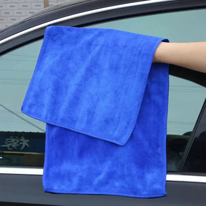 Blue microfiber car wash towel draped over a car window