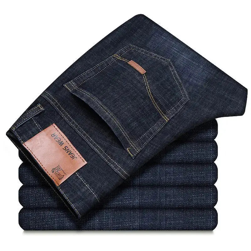 Men's dark indigo denim jeans by Simples Market, straight fit, stacked with brown leather patch