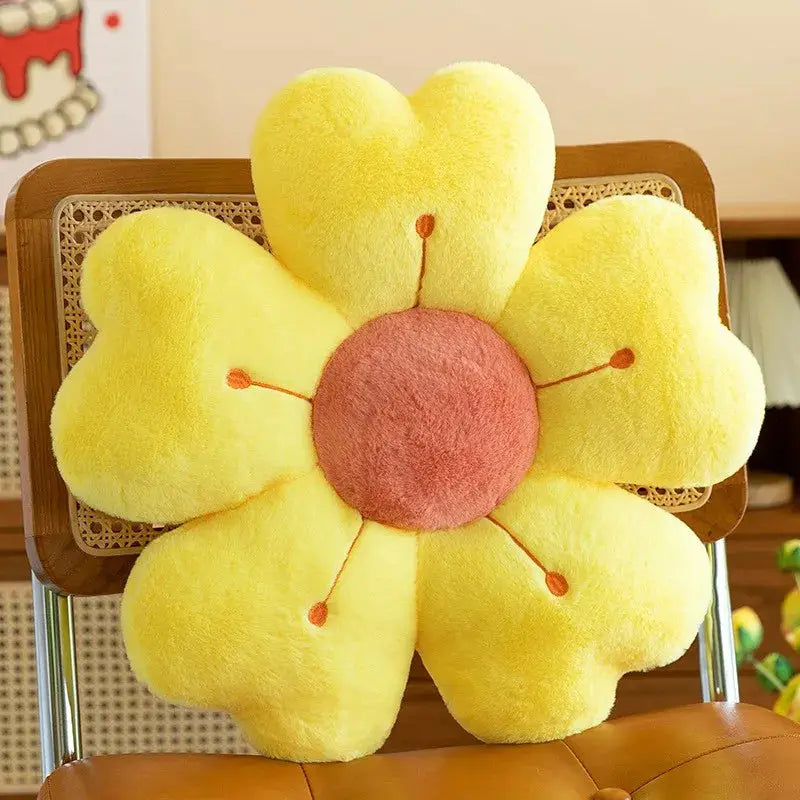 Flower-shaped plush throw pillow in yellow with pink center, soft sofa or chair decor cushion.