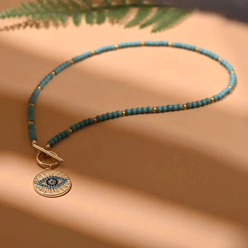 Turquoise 4mm bead choker necklace by Simples Market with round evil eye pendant