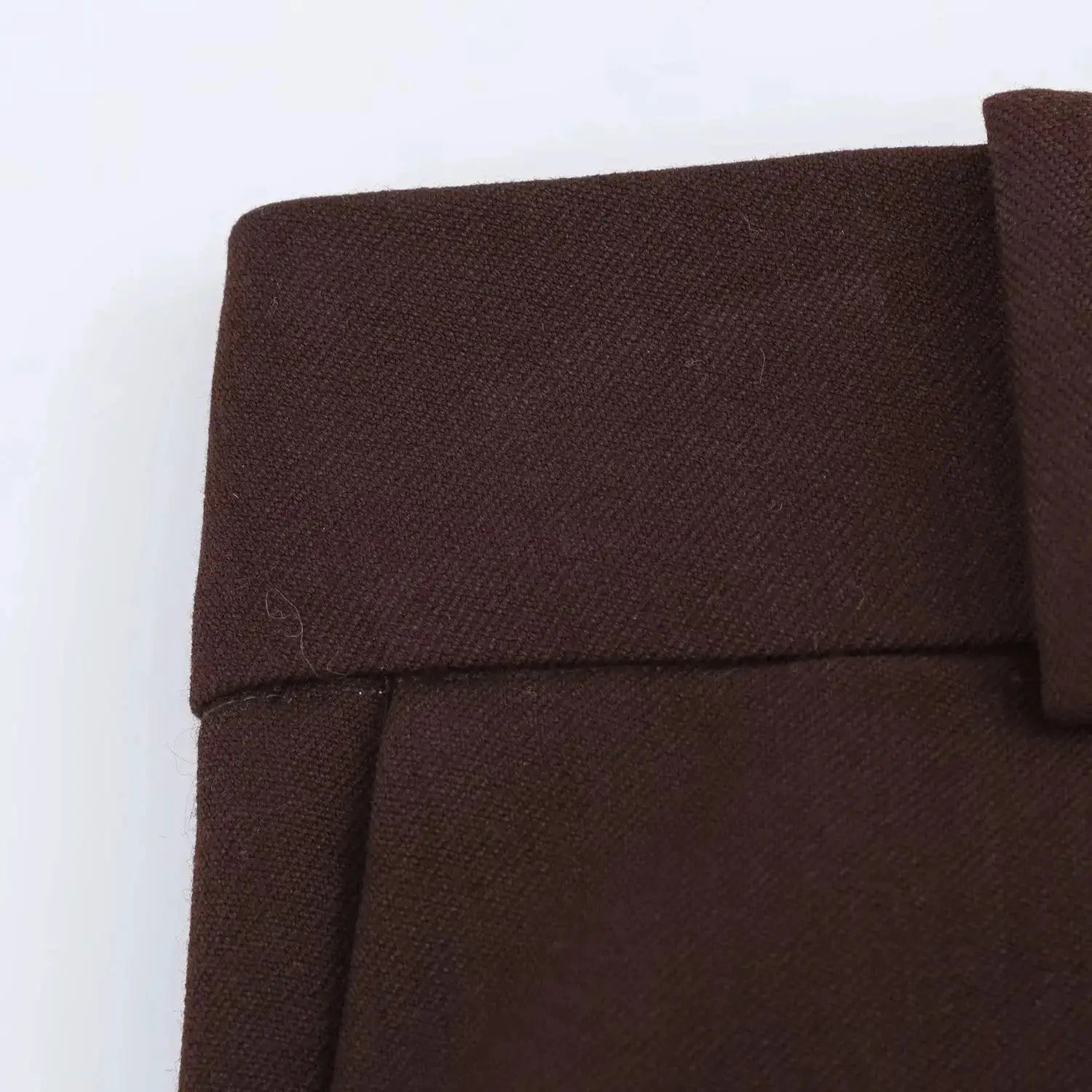 Brown blazer fabric close-up showing textured weave and seam details