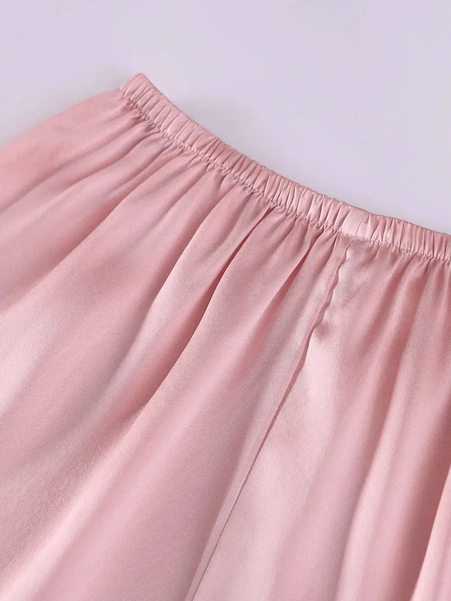 Silk shorts close-up with pale pink color and elastic waistband.