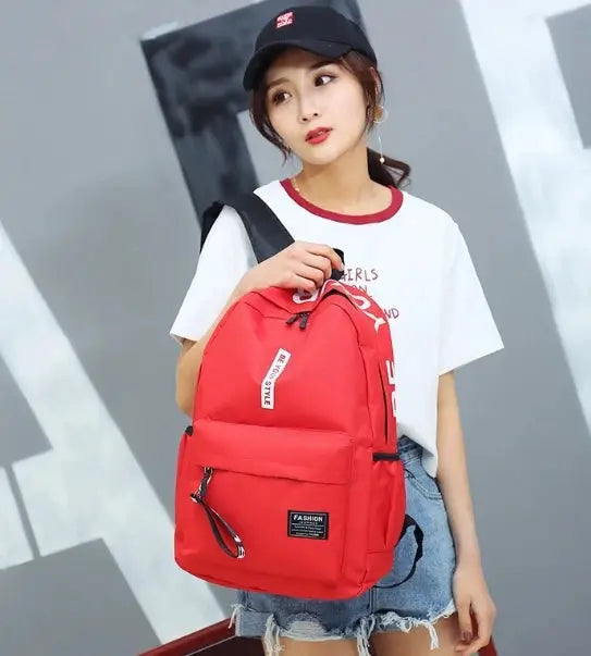 Backpack in red; unisex fashion trend style with front zip pocket and large main compartment