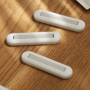 Toothpaste squeezer by Simples Market, white plastic rolling squeezers, 3-pack on wood surface