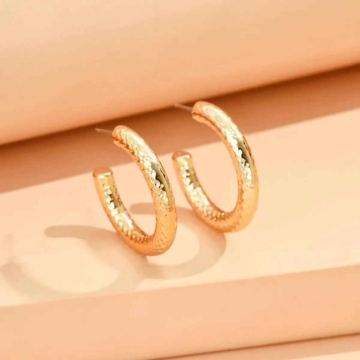 Pair of rose gold textured hoop earrings with rhinestone inlay, geometric minimalist design