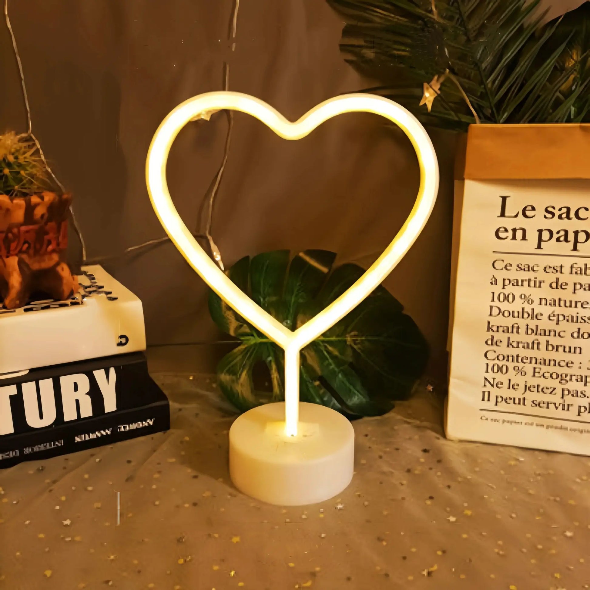 Heart-shaped neon light on a white base with warm yellow glow; battery or USB powered.