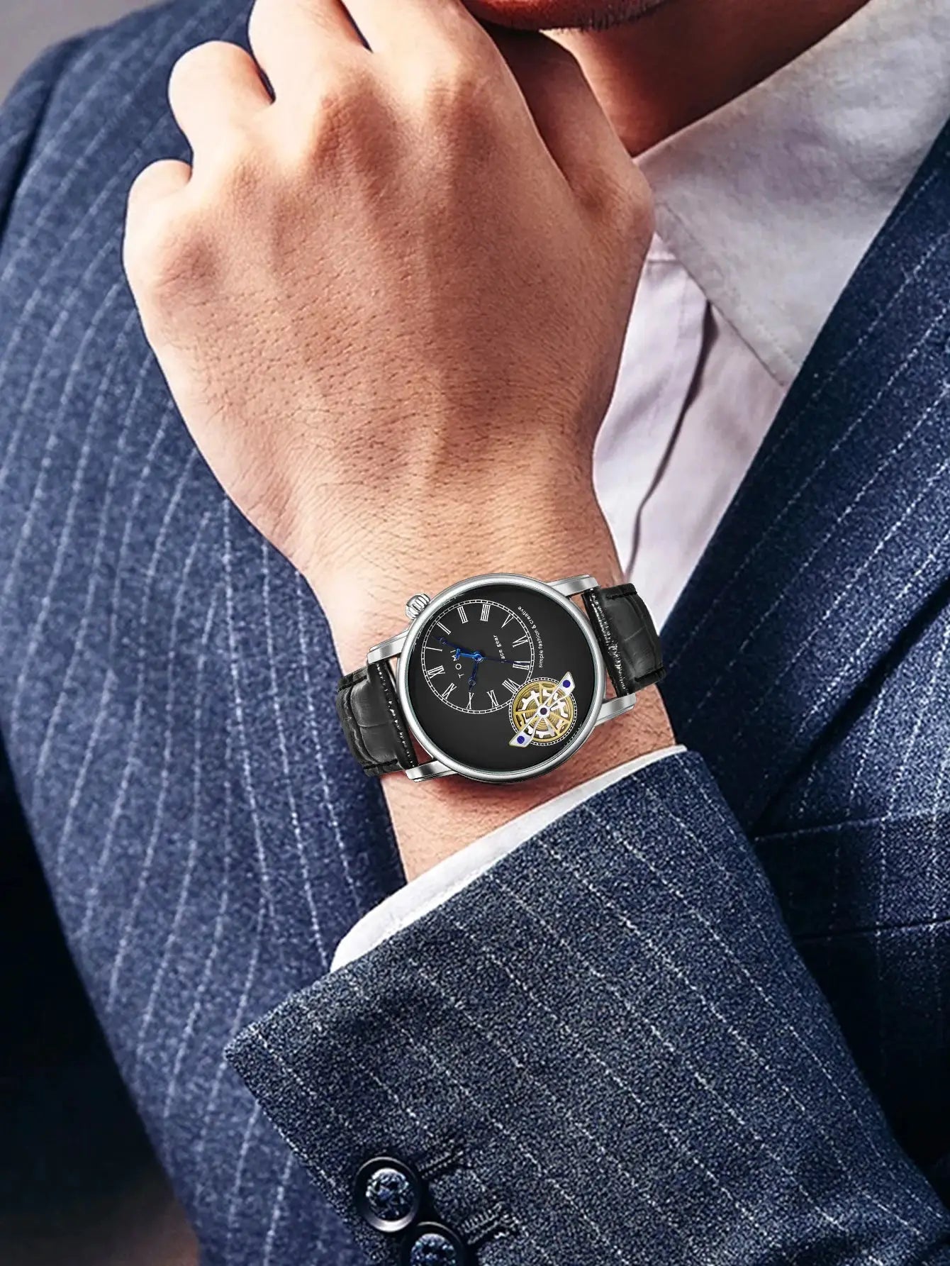 TOMI men's quartz watch with black dial, silver case and black leather strap on a suited wrist