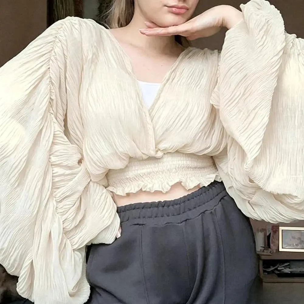 Women's cream draped chiffon blouse with V-neck and oversized puff sleeves, cropped smocked hem