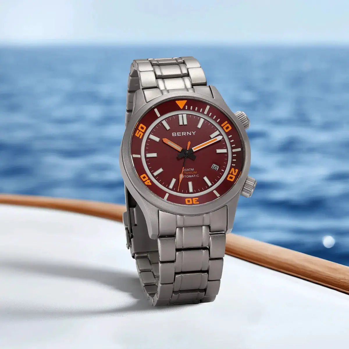 BERNY 20ATM titanium automatic diver watch with red dial, orange bezel, and stainless steel bracelet.