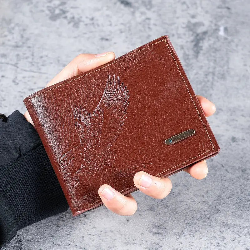 Men's slim brown leather wallet with embossed eagle pattern.