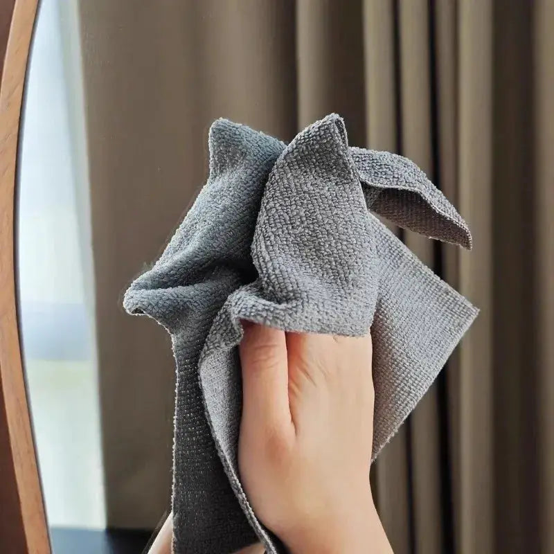 Gray reusable microfiber cleaning wipe held by hand for kitchen cleanup