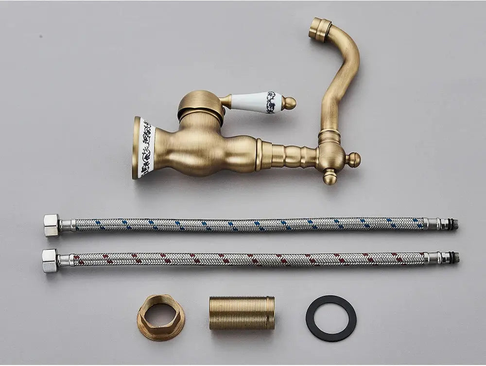 Simples Market antique brass bathroom faucet set with rotating spout, braided supply hoses, and mounting fittings.