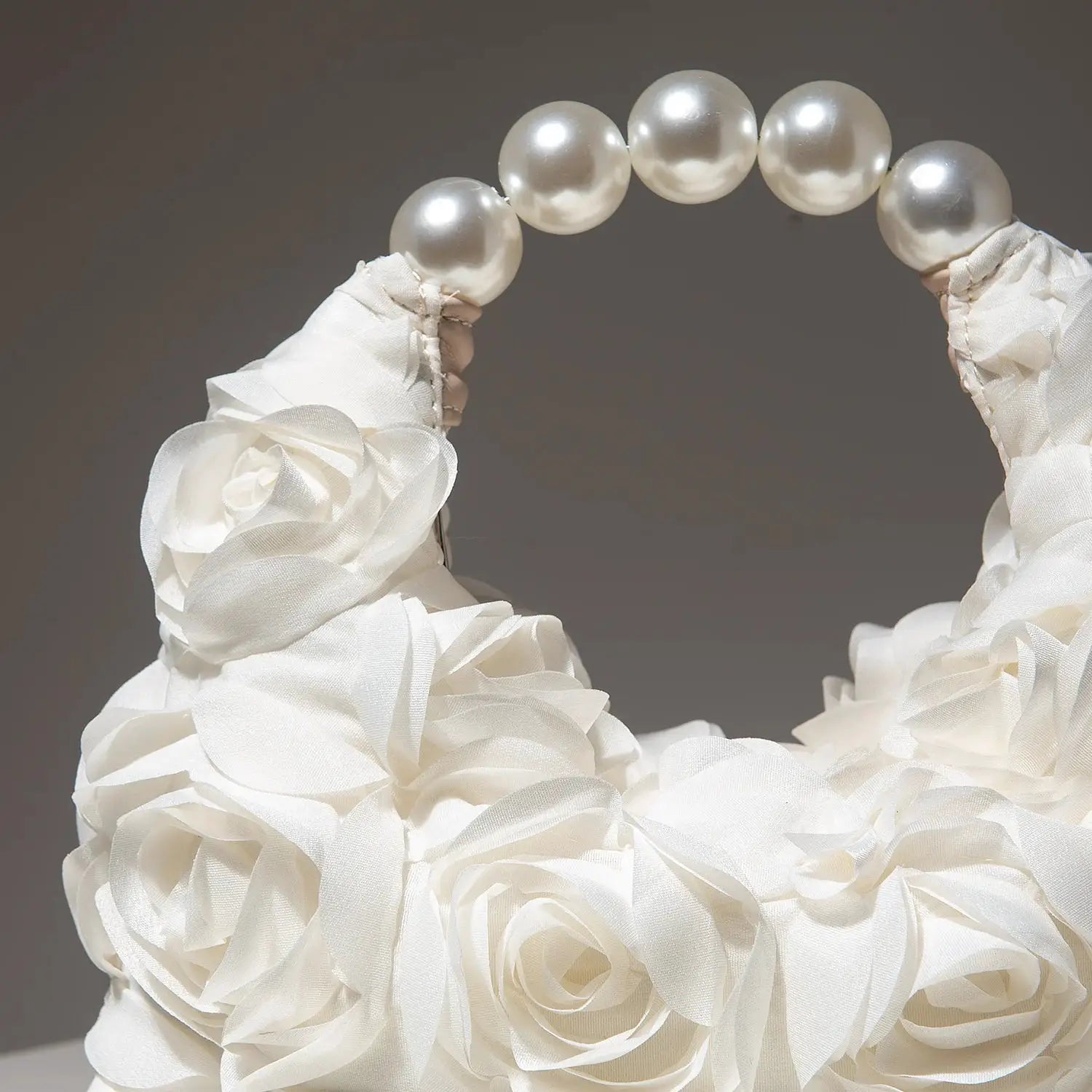 Cartera para mujer elegante con asa de perlas y rosetas de tela blancas