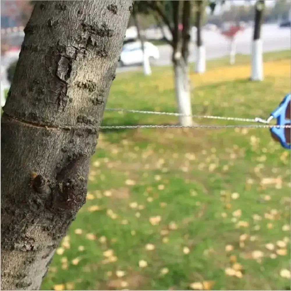 Simples Market portable survival chain saw with blue handle shown across a tree in a park