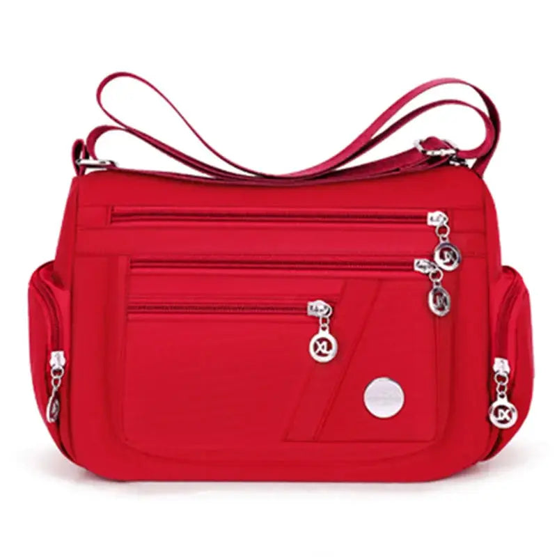 Simples Market red nylon crossbody handbag with multiple zip pockets and shoulder strap