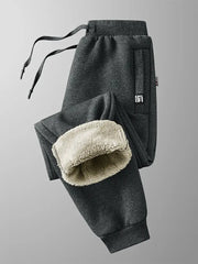 Simples Market winter men's fleece-lined sweatpants in dark gray with zip pockets and drawstring; beige fleece lining visible.