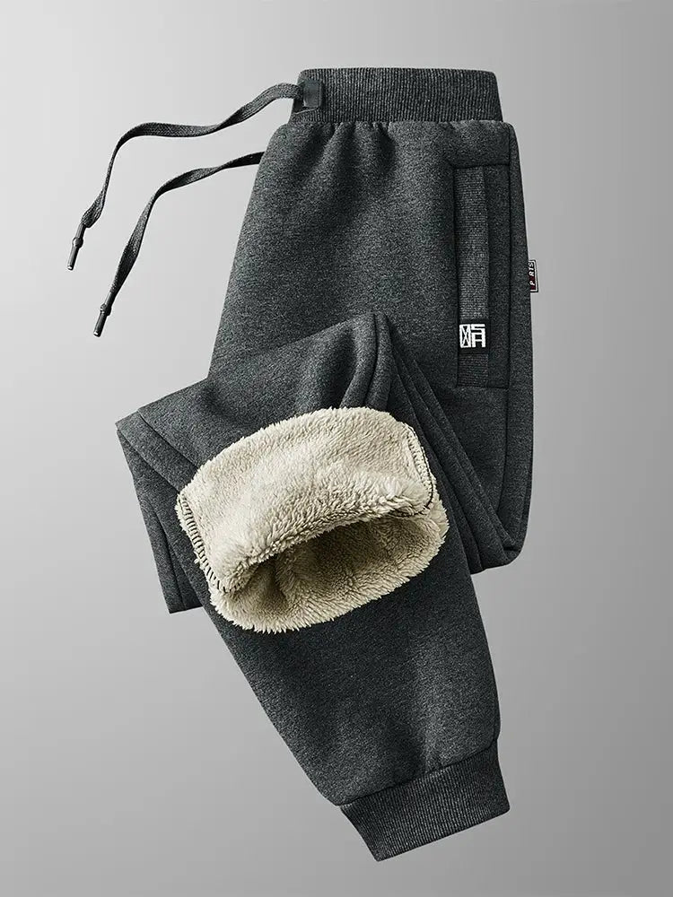 Simples Market winter men's fleece-lined sweatpants in dark gray with zip pockets and drawstring; beige fleece lining visible.