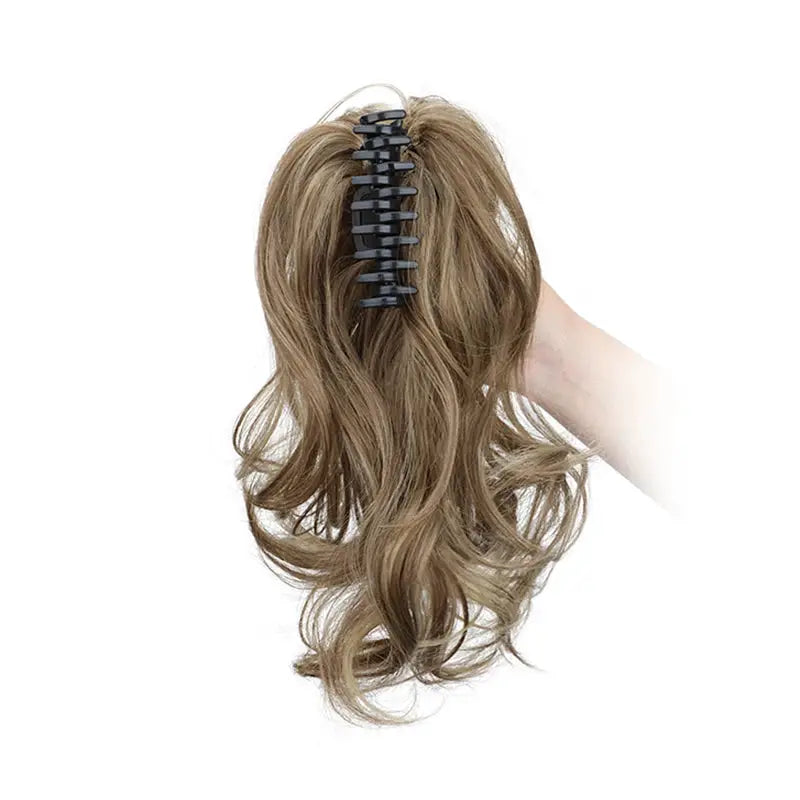 Ponytail extension by Simples Market, synthetic 12-inch with black claw clip in blonde-brown curls.