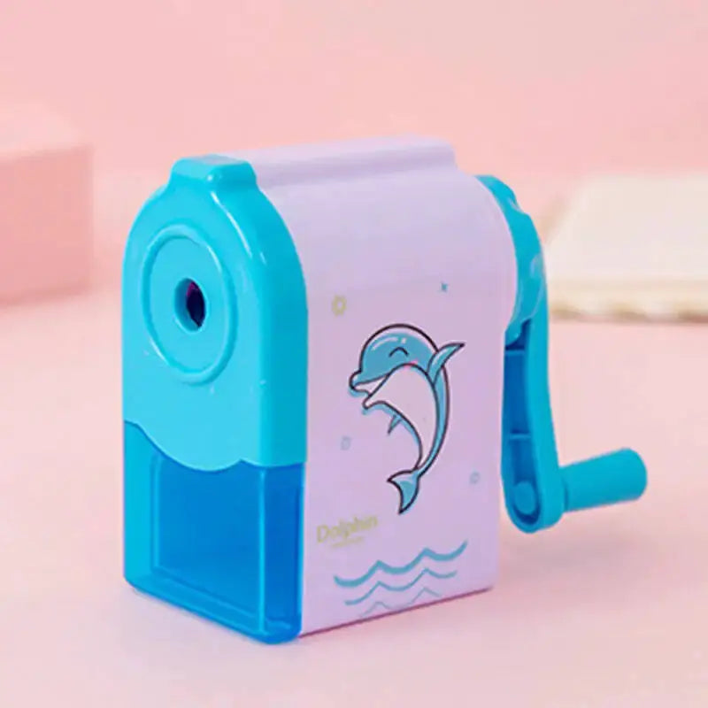 Dolphin mechanical pencil sharpener by Simples Market; blue body with lavender panel and dolphin graphic, hand crank