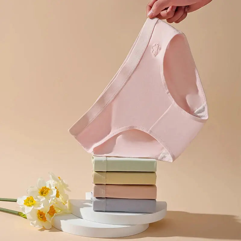 Panties pink cotton women's underwear; pink on top with five pastel-colored panties stacked beneath.