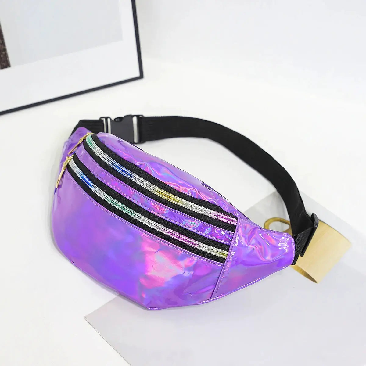 Holographic purple PU waist bag with three zip pockets and adjustable black strap.