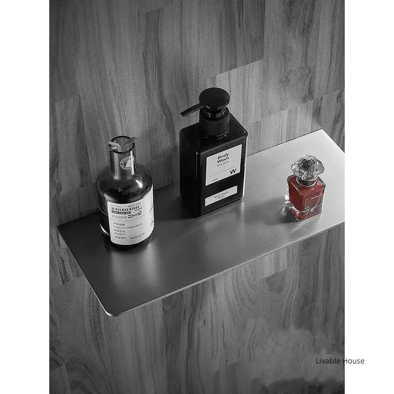 304 stainless steel brushed chrome corner bathroom shelf, wall-mounted, with three bottles.