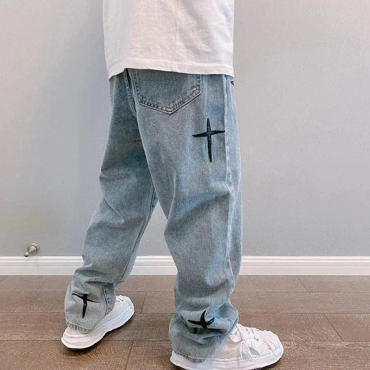Men's light-blue denim cargo pants with black star prints, loose wide-leg fit.