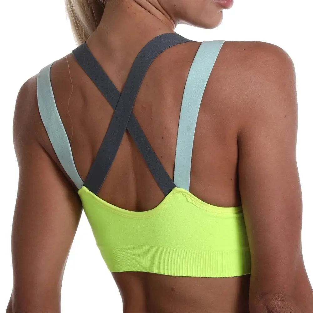 Cross-back sports bra in neon lime with gray X-straps and pale blue shoulder straps