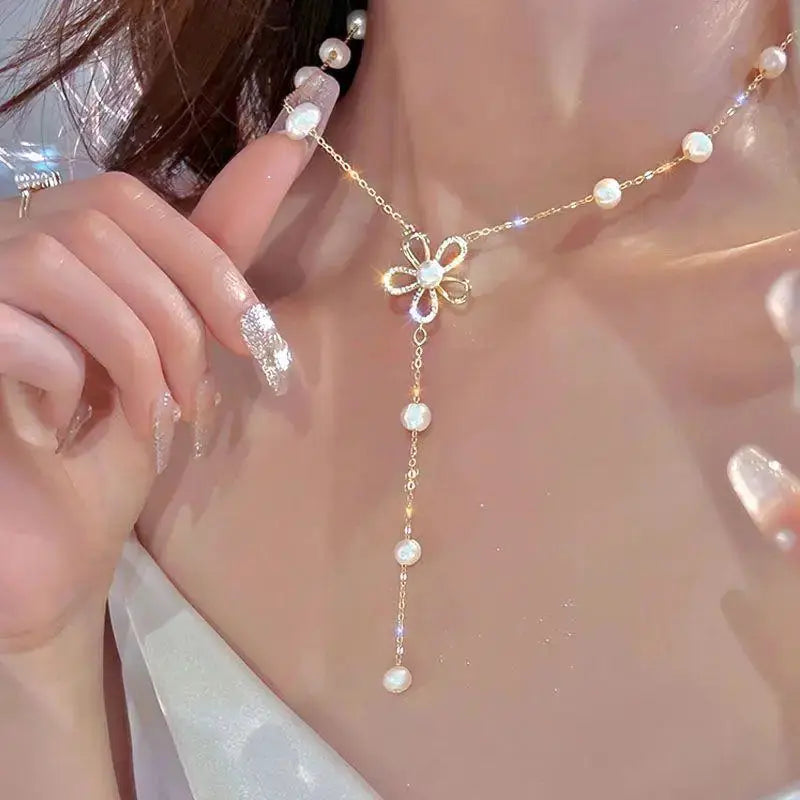 Kpop pearl choker necklace with gold-tone chain, floral pendant, and pearl drop.