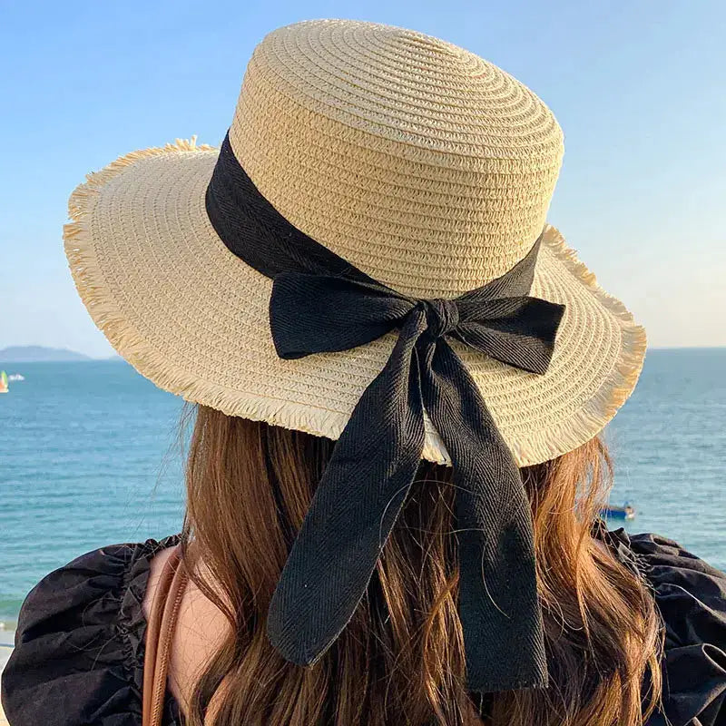 Simples Market Korean Bow Straw Hat for Women with wide brim and black ribbon bow, beach backdrop