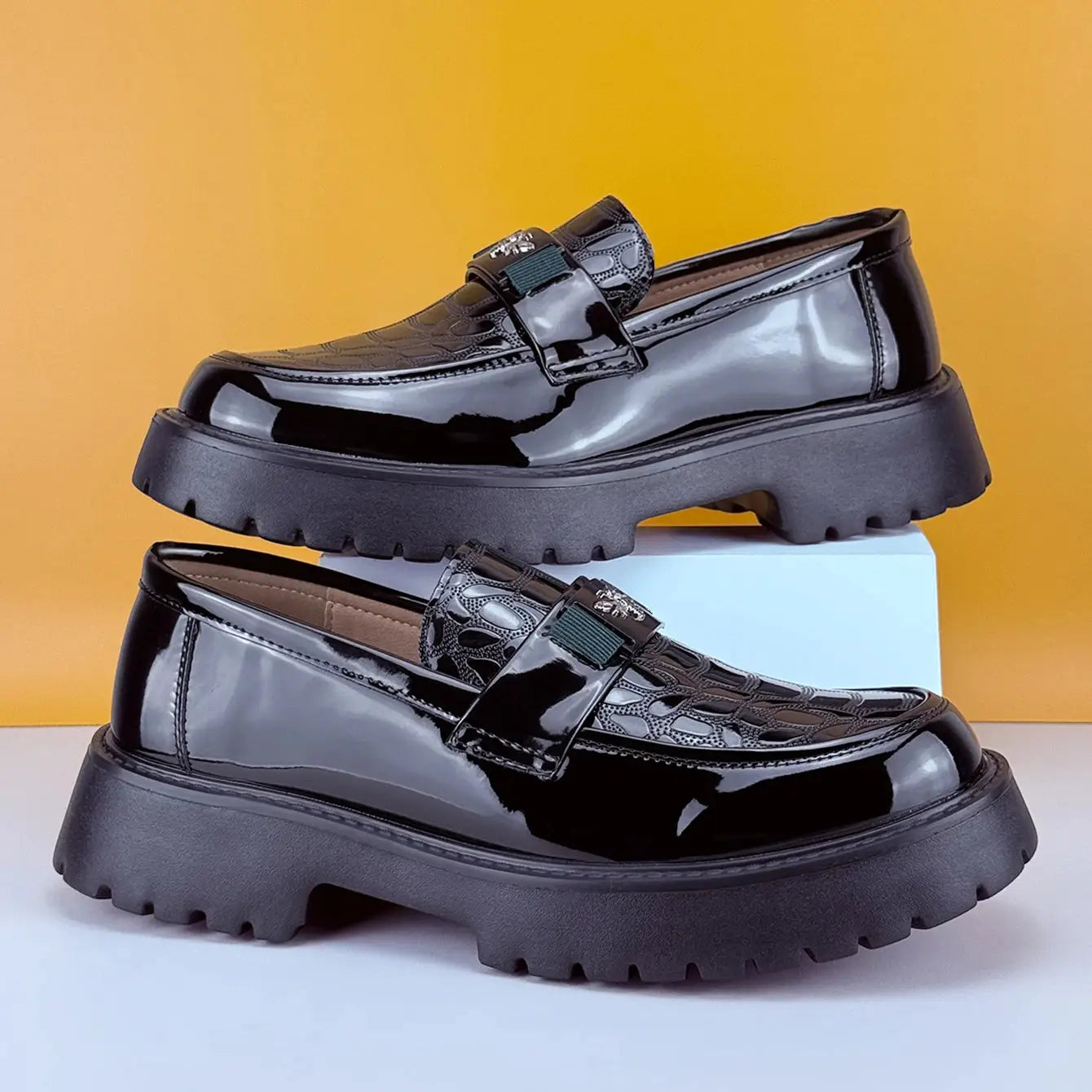 Pair of men's black patent leather slip-on loafers with chunky platform sole