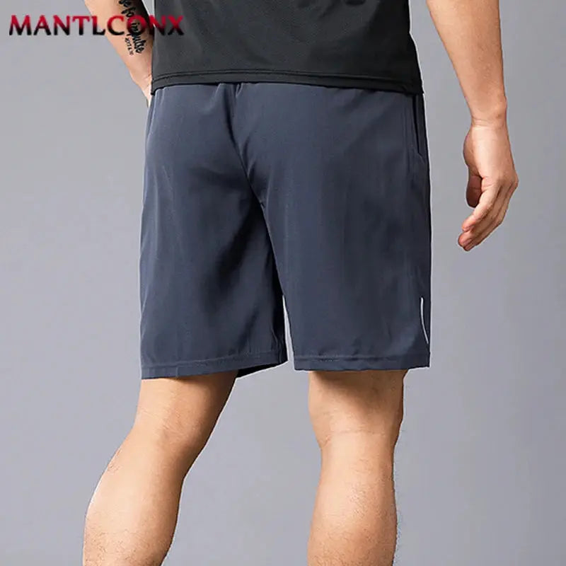 Men's navy quick-dry jogging shorts; MANTLCONX logo visible.