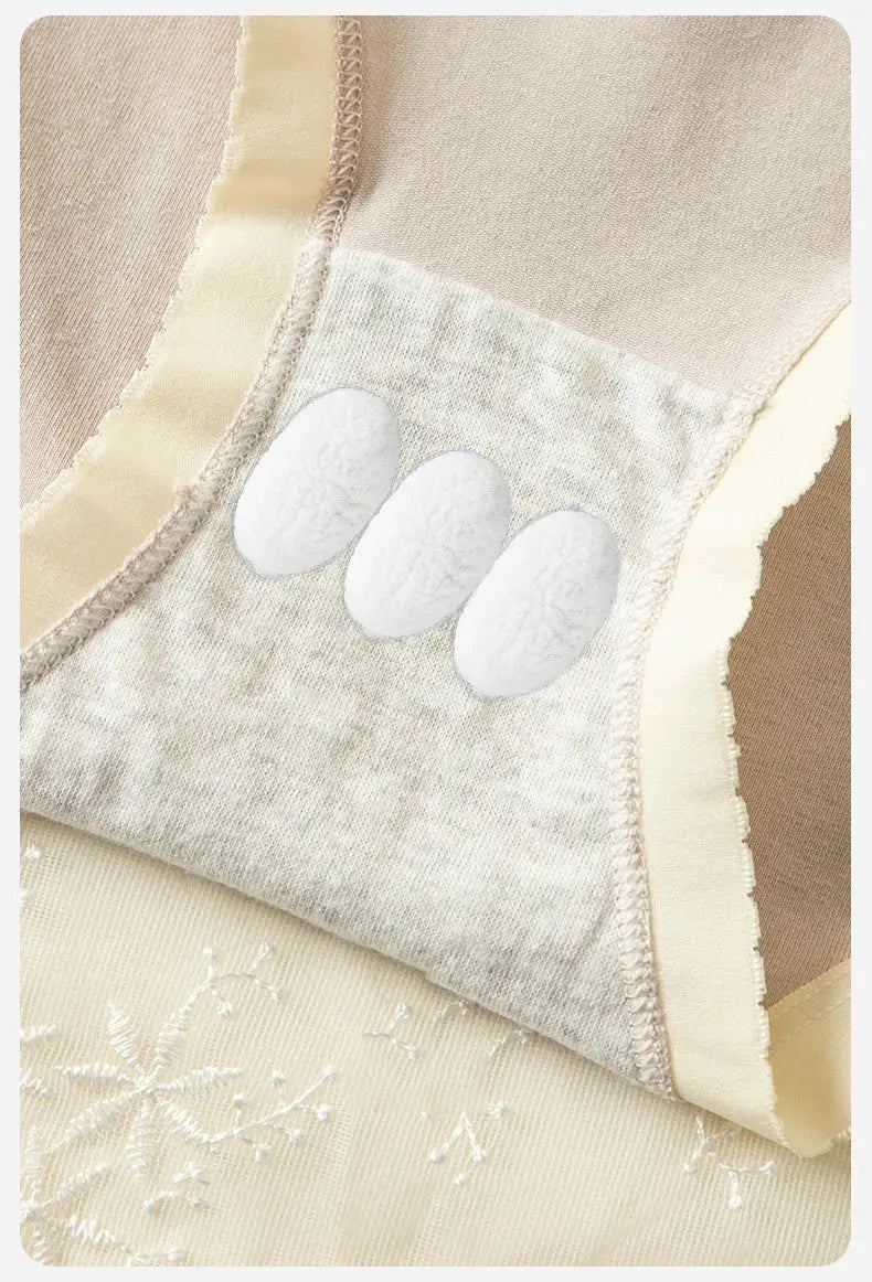 Beige cotton women's panties with lace trim and three white oval pads.
