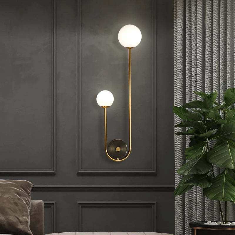 Modern gold wall lamp with dual glass globe shades and LED