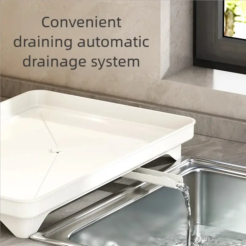 White plastic kitchen draining rack over stainless steel sink with built-in drain spout