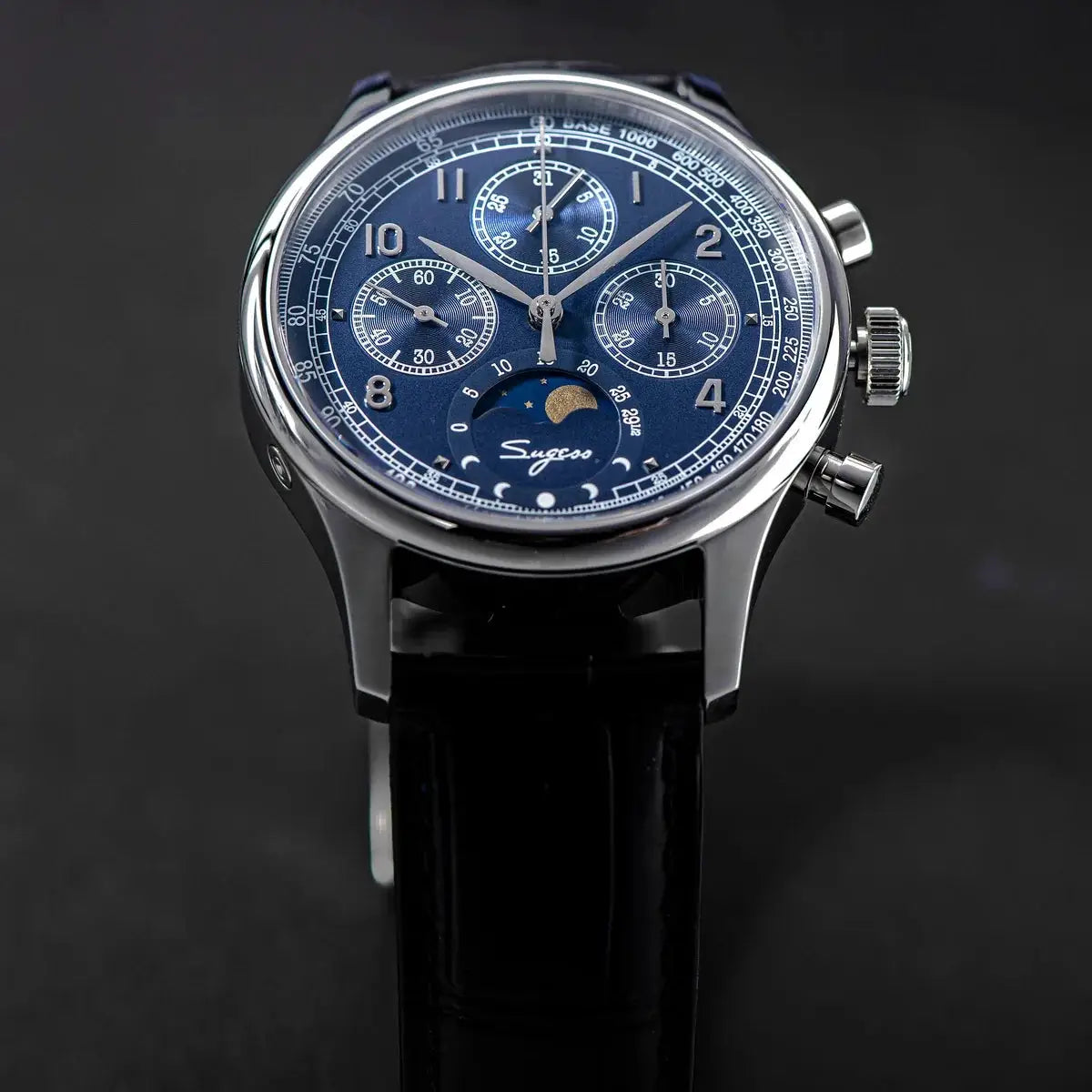 Sugess men's chronograph watch with blue dial, moonphase indicator, stainless steel case, and black leather strap.