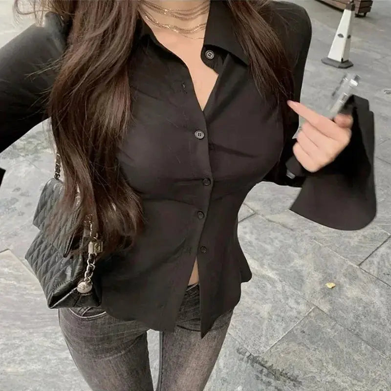 Black single-breasted blouse with flared sleeves and a lapel collar, fitted tunic style