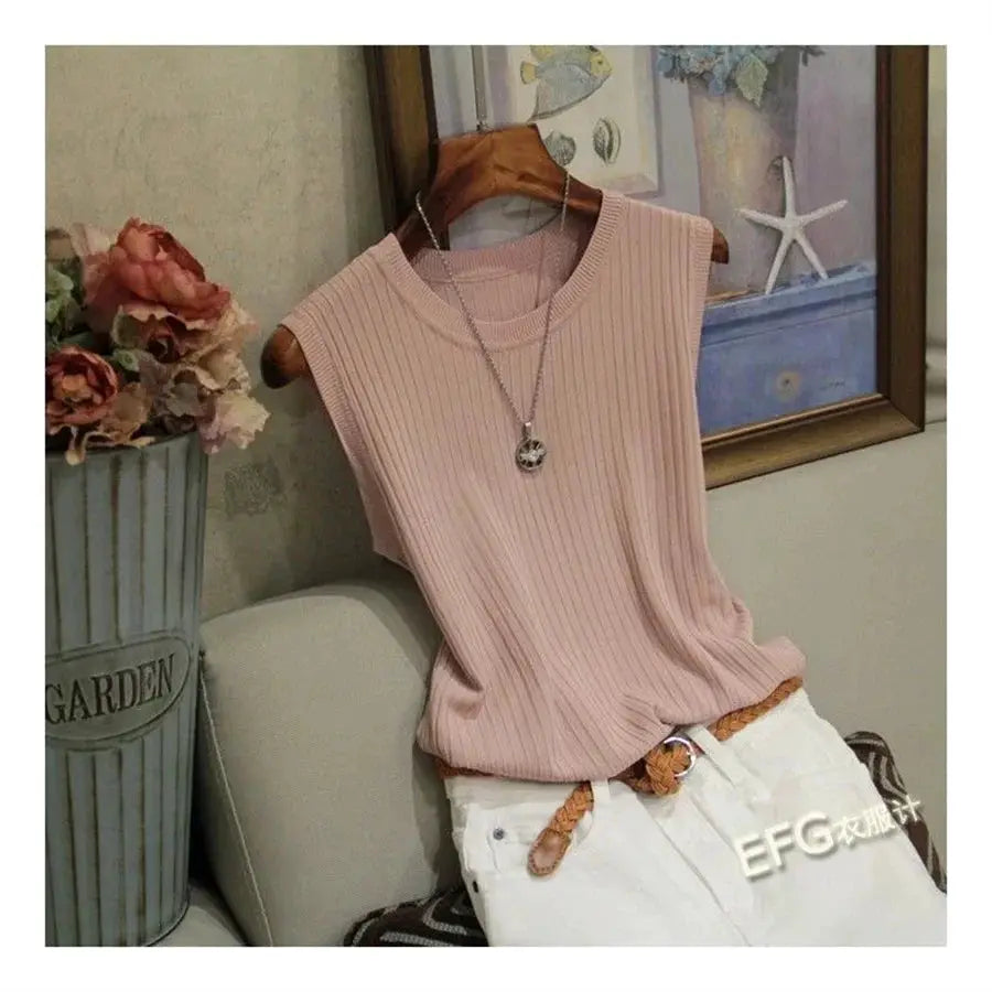 Pink sleeveless knitted blouse with O-neck, ribbed texture, shown with white pants