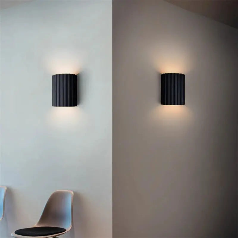 Nordic Modern Resin Wall Lamp by Simples Market; pair of black ribbed resin wall lights with warm glow.