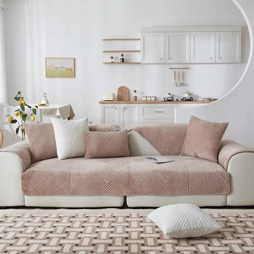 Crystal Velvet Sofa Cover in blush pink, quilted non-slip slipcover for living room on a white sofa.