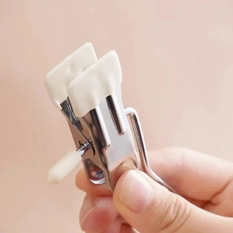 Stainless steel clothespin with white plastic tips held in hand; compact laundry clip for clothes organization