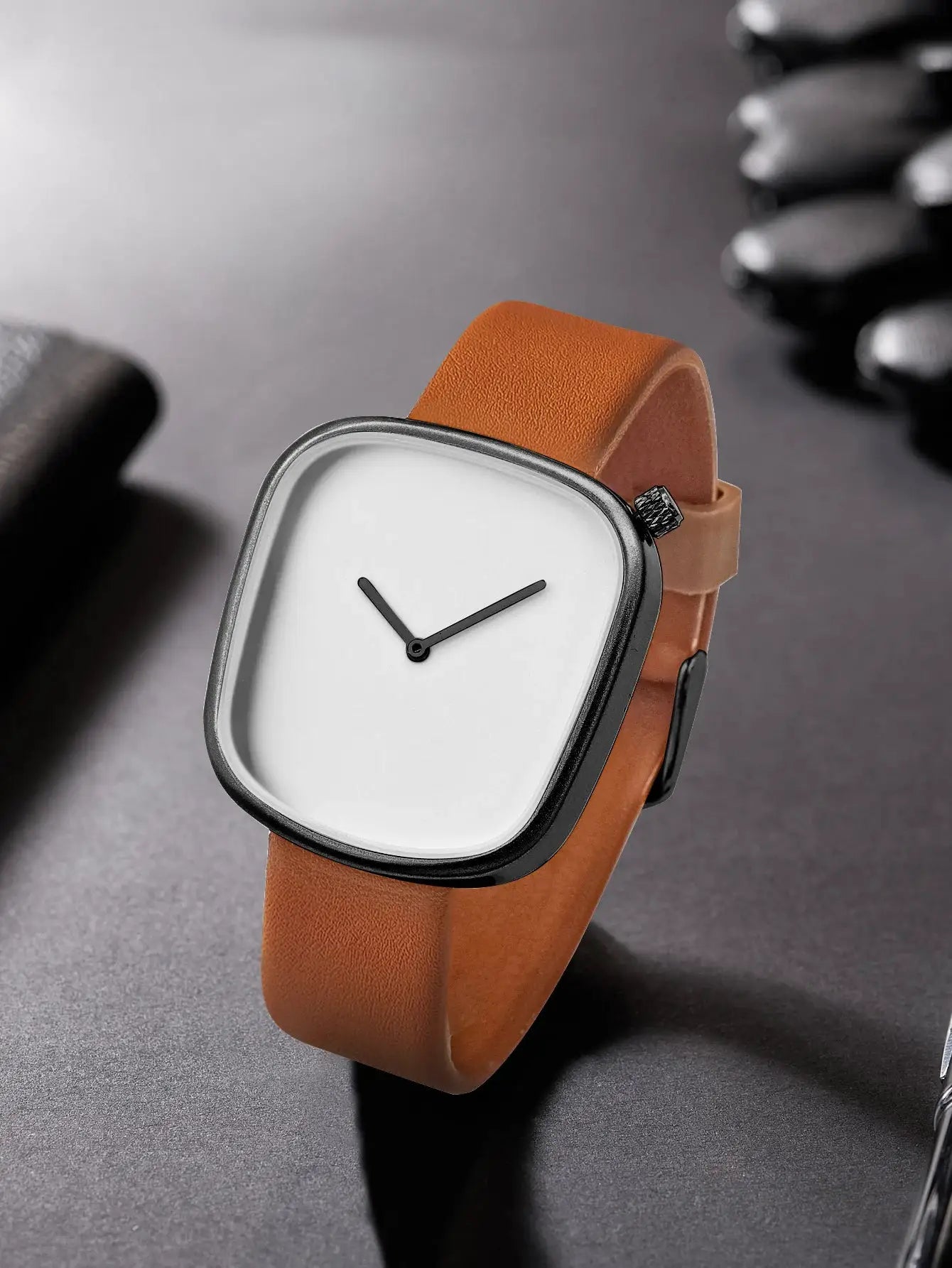 TOMI watch with tan leather strap and black square case, minimalist white dial