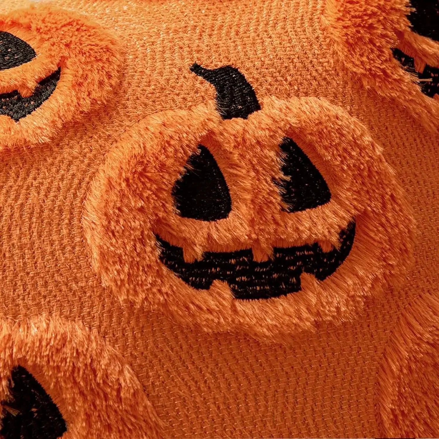 Throw pillow cover orange plush faux fur with black jack-o'-lantern face pattern, 18x18