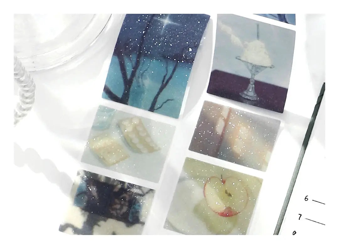 Six decorative PET tape samples with scenic images and glitter on white background