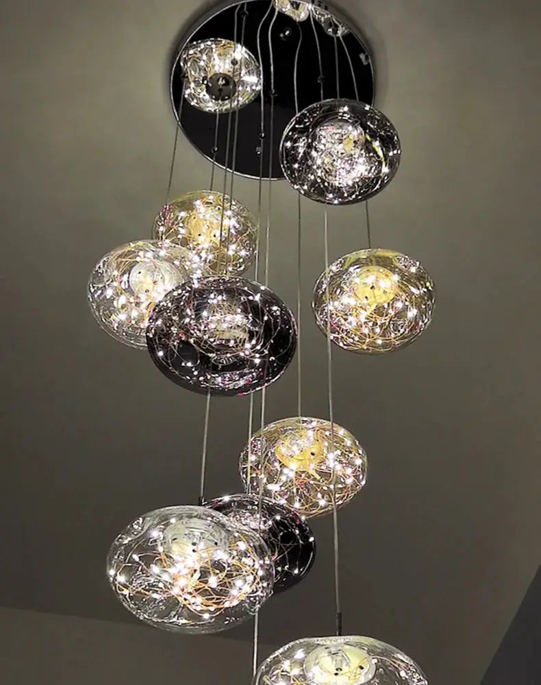 Pendant light cluster with multiple clear glass globe orbs and warm LED illumination