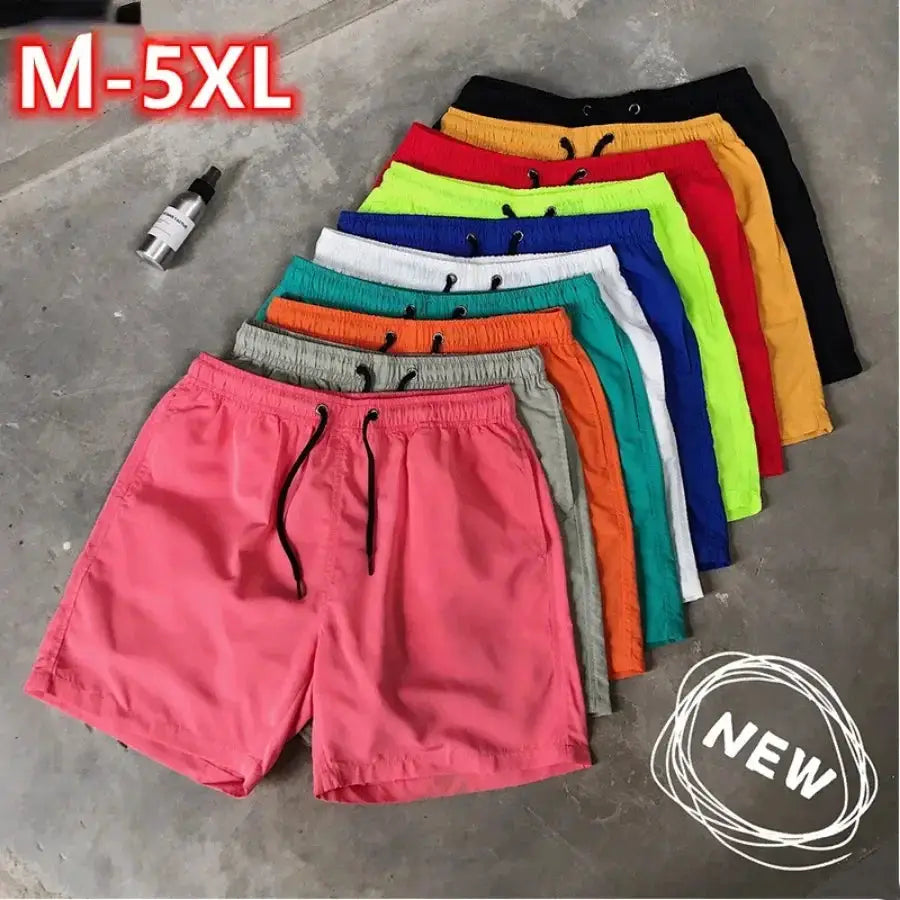 Men's swim shorts set in assorted colors, M-5XL; pink pair front with black drawstring amid rainbow stack