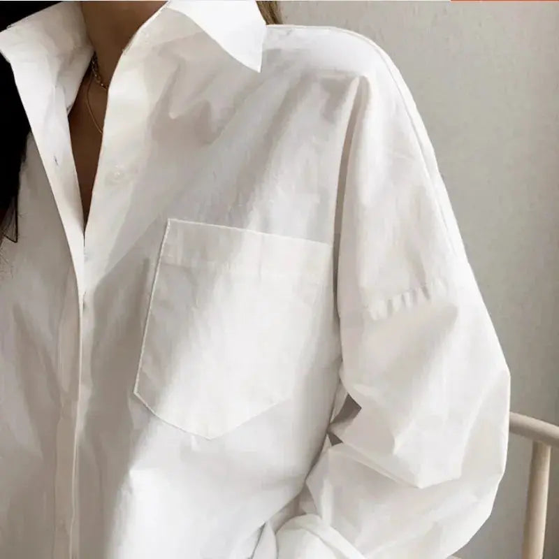 White cotton long-sleeve blouse by Simples Market with turn-down collar and chest pocket.
