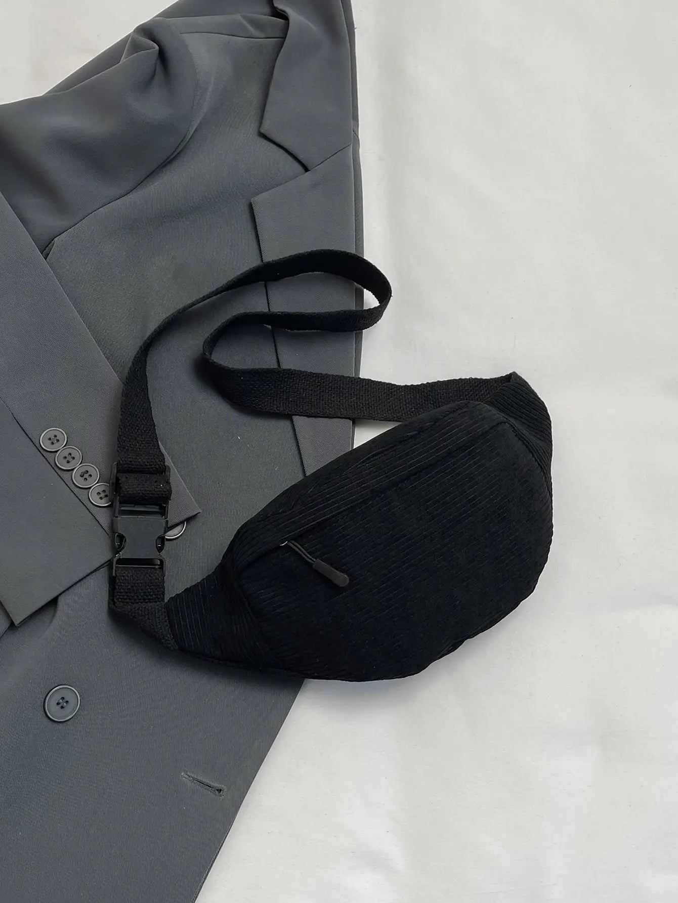 Simples Market black fanny pack with adjustable strap worn over a gray blazer