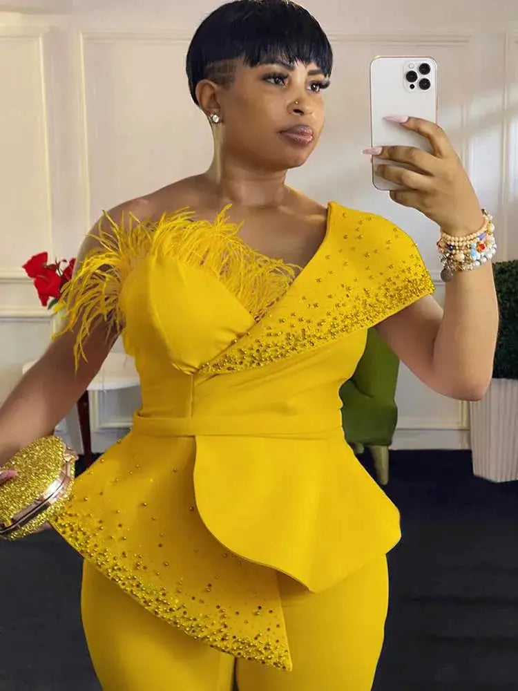 Yellow strapless high-waist jumpsuit by Simples Market with feathered accent and rhinestone overlay