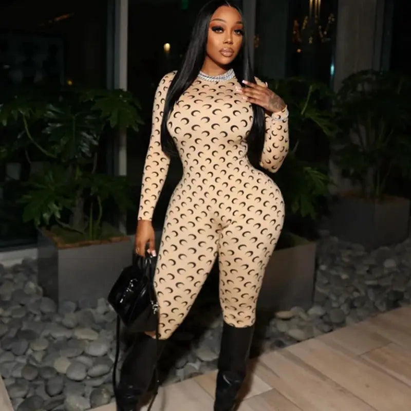 Womens jumpsuit beige with black crescent moon print, long sleeves, round neck, tight fit.